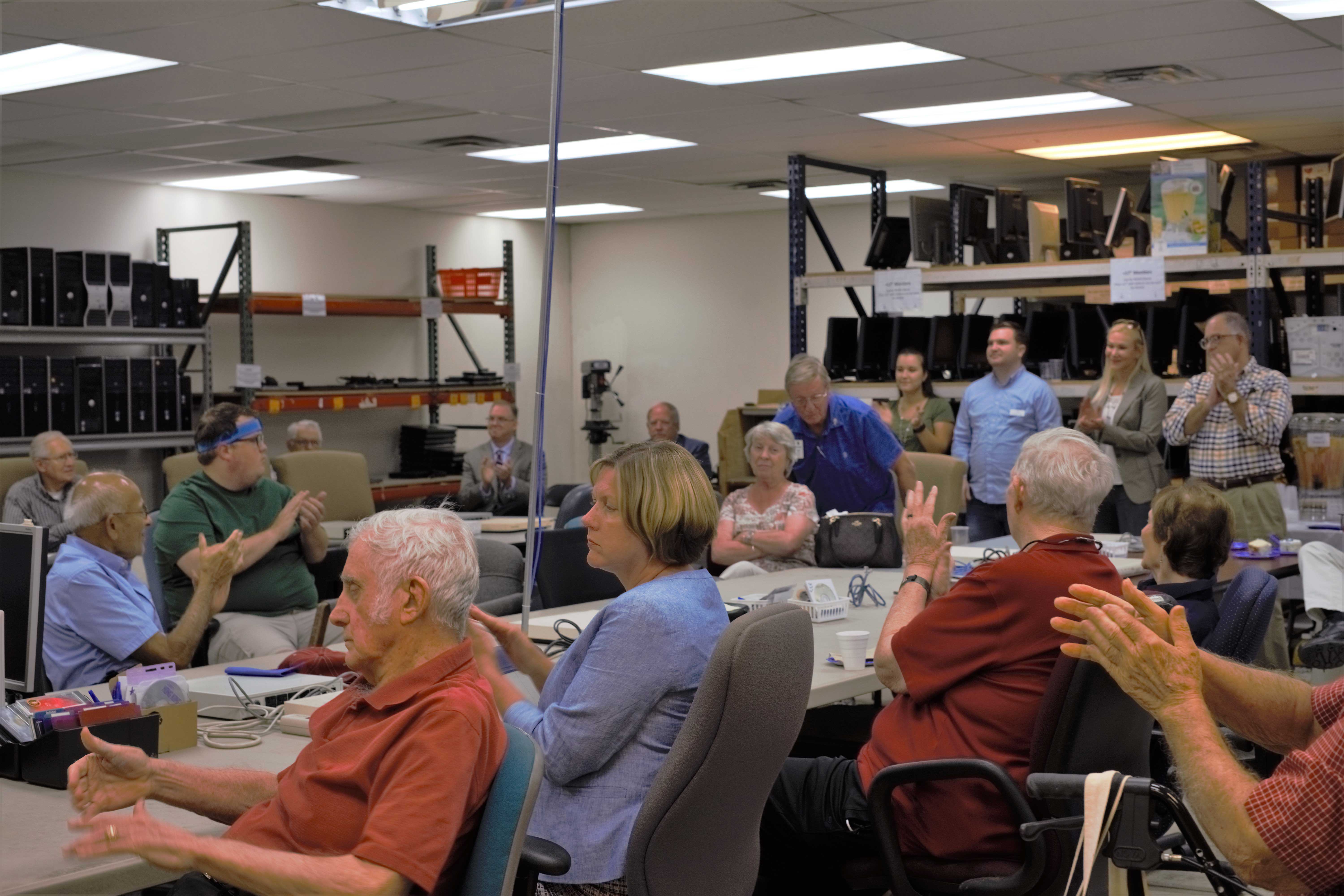 Volunteers, community members, and others participate in the presentation of the 10,000th computer.