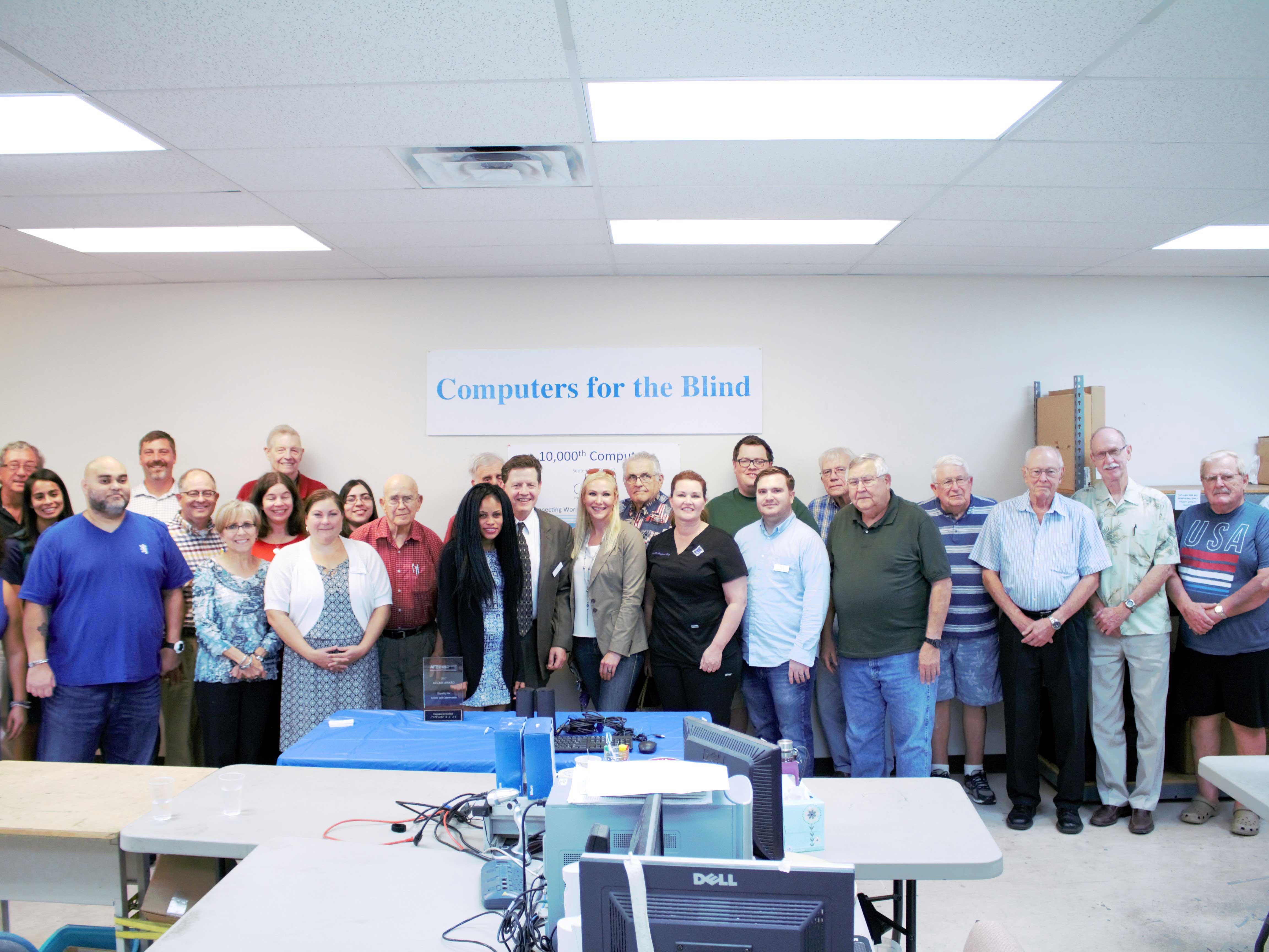 Volunteers, community members, and others participate in the presentation of the 10,000th computer.